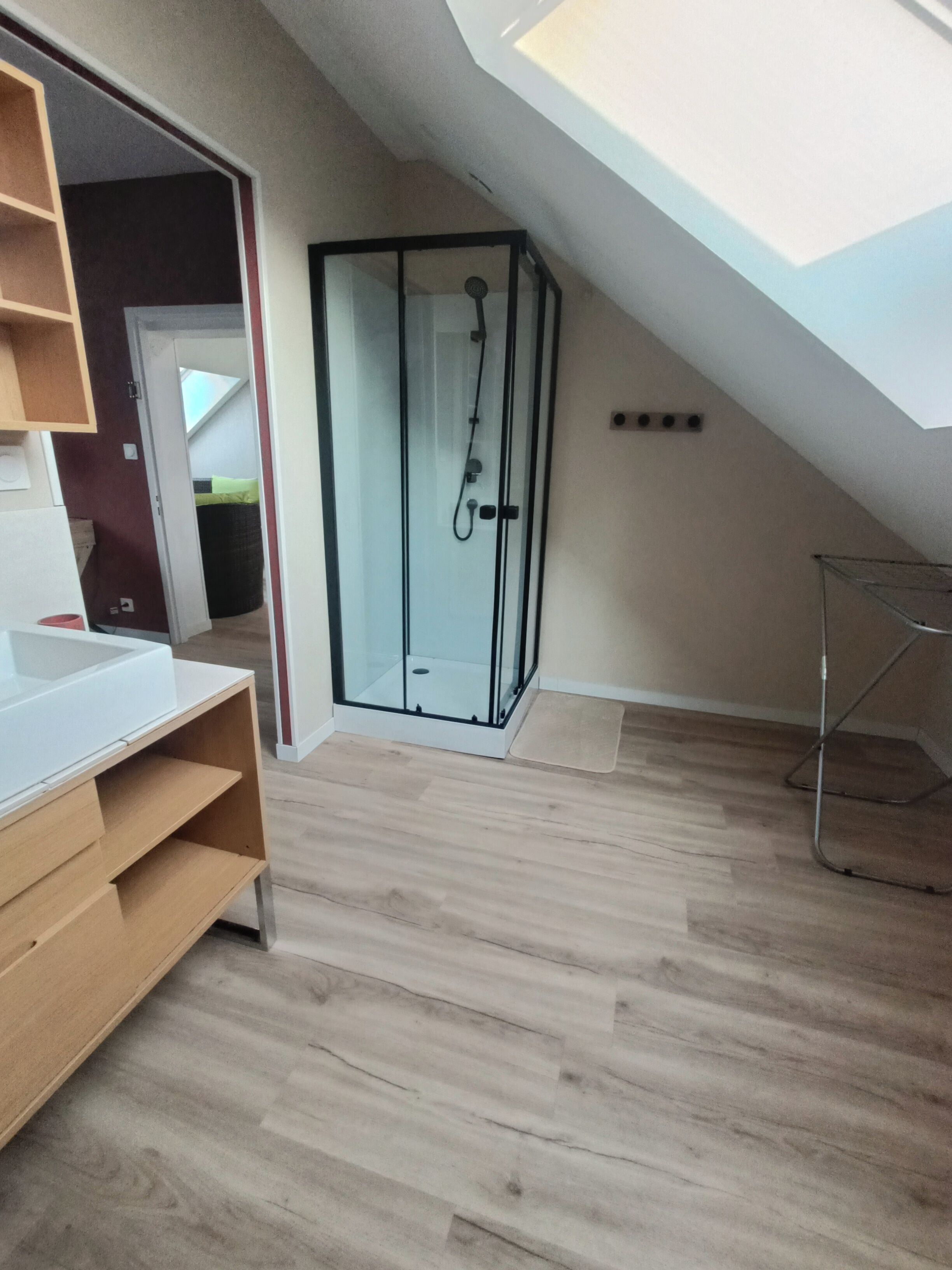 Une salle de bain moderne avec une douche à parois de verre et un meuble-lavabo en bois.