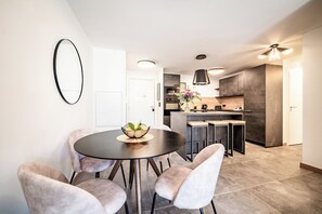 Una cocina moderna con armarios oscuros, una isla central e iluminación colgante.