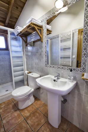 A bathroom with a toilet, sink, and shower.