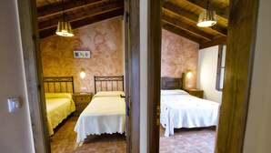 A room with two beds, a wooden ceiling, and a tiled floor. - Les Xanes: El Trasgu - mountain views, terrace, and Wi-Fi (Cangas de Onís)