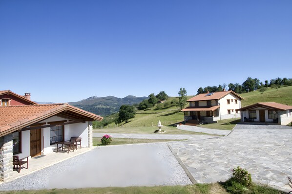 A residential area with houses, a paved driveway, and a fountain.