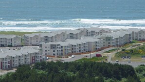 Een kustgebied met woonhuizen, appartementencomplexen, een weg en een strand op de achtergrond.