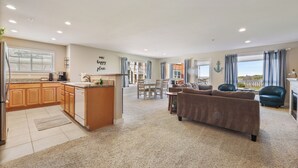 Een ruime woonkamer met een keuken, een eettafel en een bank.