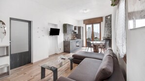 A modern living room with a sofa, a coffee table, and a TV. - Apartment 'Dudi Jolie' with Lake View, Whirlpool, Terrace and Wi-Fi (Lezzeno)