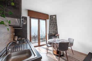 Una cocina moderna con estufa integrada, un lavamanos y un comedor con mesa y sillas.