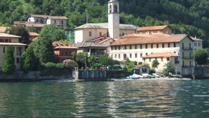 A coastal town with a prominent clock tower, terraced buildings, and a waterfront. - Apartment 'Dudi Jolie' with Lake View, Whirlpool, Terrace and Wi-Fi (Lezzeno)