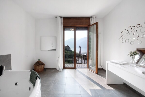 A modern bathroom with a bathtub, a sink, and a large window.