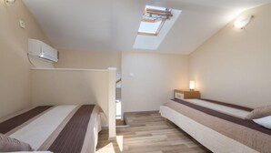 A small, modern room with two beds, a skylight, and a wooden floor. - Apartments Nmn - Studio Apartment with Balcony 3 (Drvenik)