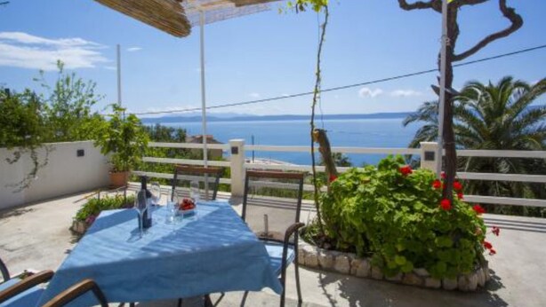 An outdoor patio with a table and chairs, a pergola, and a view of the sea. - Sea ViewApartments Lendic Podgora- Superior Studio (Podgora)