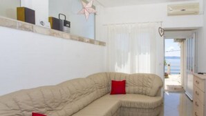 A modern living room with a beige sectional sofa, a red pillow, and a star decoration on the wall.