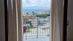 A balcony with a view of the sea and buildings.