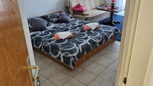 Une chambre à coucher avec un lit, un canapé et une petite table sur laquelle est posée une plante.