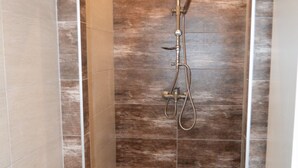 Eine Dusche mit Handbrause und Handarmatur.