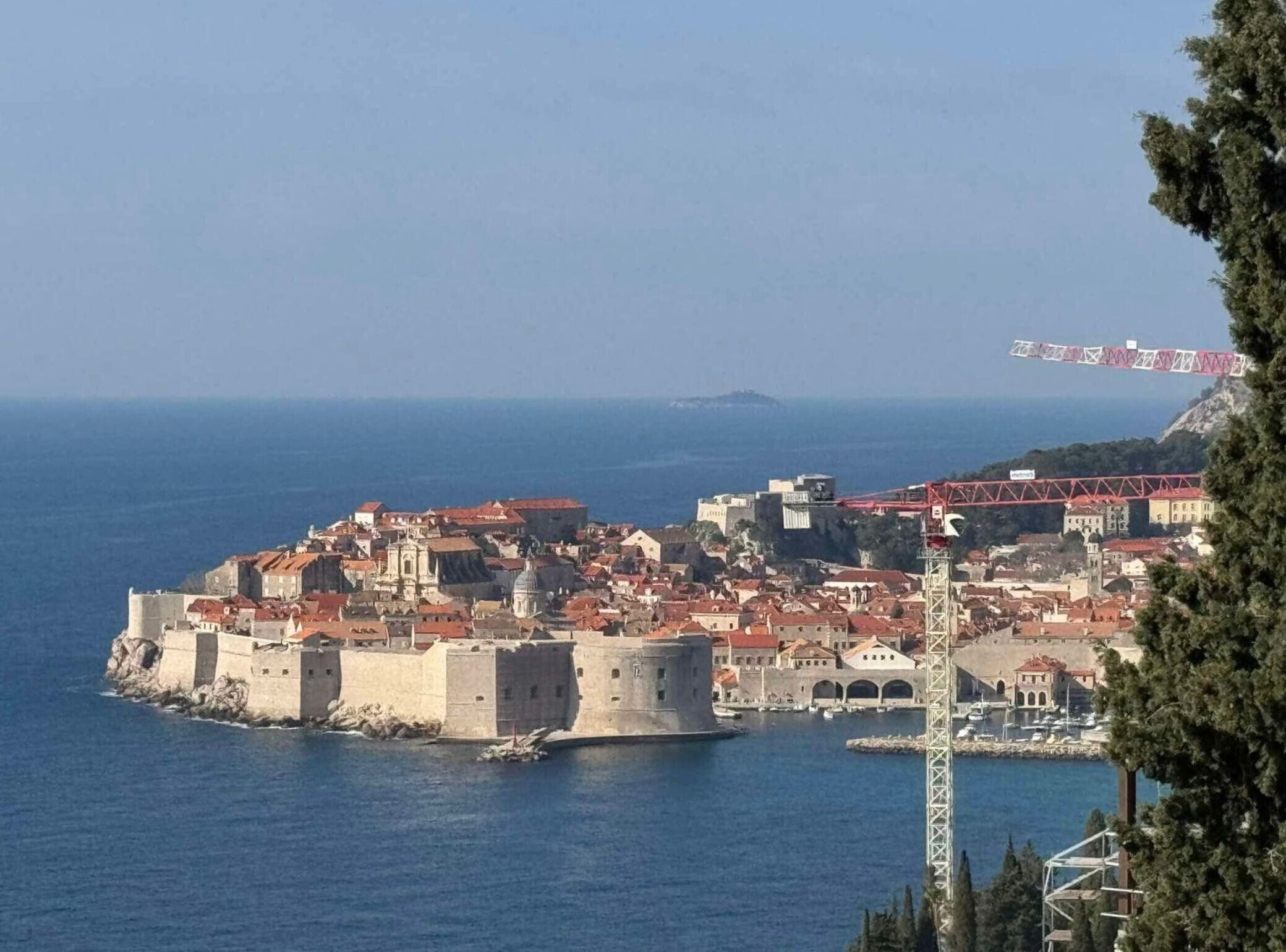 Une ville côtière dotée d’une architecture historique, notamment d’une imposante structure fortifiée et d’un pont.