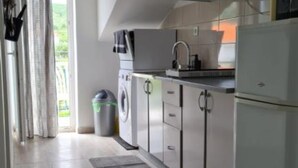A modern kitchen with a built-in oven, a sink, and a trash can. - Apartments Silva - Superior Two Bedroom Apartment with Balcony and Sea View (Slatine)