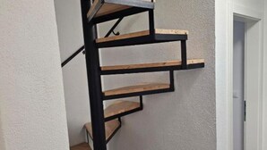 A spiral staircase with wooden steps and black metal railings. - Spacious Villa/Outdoor Pool in Trogir - 3 Bedroom (Trogir)