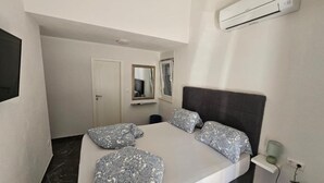 A bedroom with a bed, a mirror, an air conditioning unit, and a small shelf. - Spacious Villa/Outdoor Pool in Trogir - 3 Bedroom (Trogir)