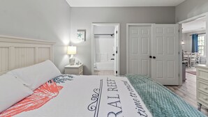 A bedroom with a bed, nightstand, and a door leading to a bathroom.