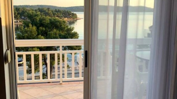 A balcony with a view of a lake and trees. - Apartments Tomi - Studio With Balcony (10) (Trogir)