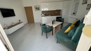 A modern apartment with a dining area, kitchen, and living room. - Apartments Tomi - Double Room With Sea View (3) (Trogir)