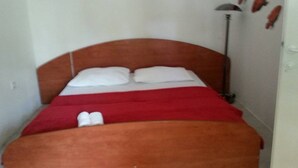A single bed with a wooden headboard, white pillows, and a red blanket. - Apartments Štrbić - One Bedroom - Nina (Karin Gornji)