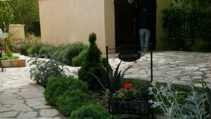 A stone pathway leading to a building with a 'WELCOME' sign. - Apartments Štrbić - One Bedroom - Nina (Karin Gornji)