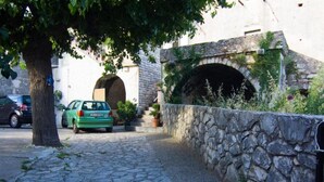 A cobblestone street with a stone wall and a tunnel entrance.