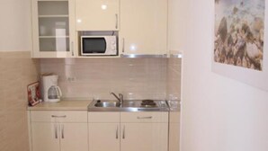 Une cuisine équipée d’un four à micro-ondes, d’un évier et de placards.