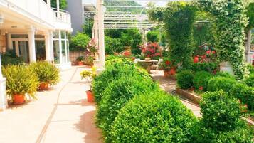 A covered outdoor area with potted plants and a pathway.