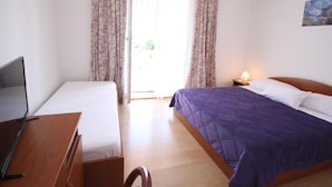 A bedroom with a bed, a desk, and a chair. There is a window with curtains and a painting on the wall. - Double Room With Sea View 7 (Mlini)