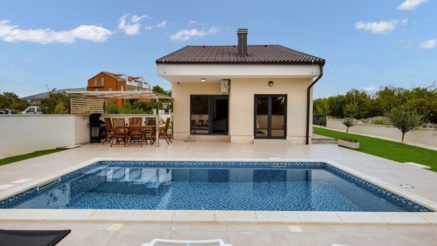 A modern house with a swimming pool, a patio with outdoor furniture, and a clear blue sky. - Villa Shaula 2 - Three Bedroom House with Pool (Šibenik)