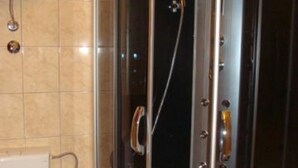 Un baño moderno con ducha de vidrio, inodoro y lavamanos.