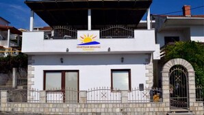 A two-story building with a sign reading "APARTMANI KRIVAC" and a sun symbol. - Apartments Višnja - Classic One Bedroom Apartment (Klek)