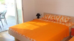 A bedroom with a bed, a nightstand, a lamp, and a chair. - Apartments Višnja - Classic One Bedroom Apartment (Klek)