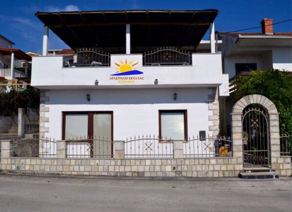 A two-story building with a sign reading "APARTMANI KRIVAC" and a sun symbol. - Apartments Višnja - Standard One Bedroom Apartment (Klek)