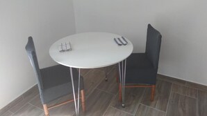 A small, round table with two chairs, a white tablecloth, and a folded cloth on the table. - Seafront Charming Apartments Kosirina Studio 4 (Brna)