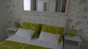 Ein Schlafzimmer mit einem Bett, zwei Nachttischen und einem Spiegel.