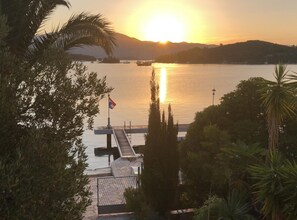 Un coucher de soleil sur un lac paisible, avec un quai et un drapeau.