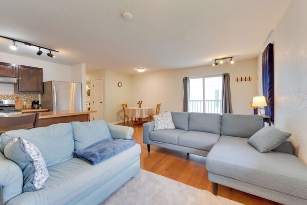Ein modernes Wohnzimmer mit zwei Sofas, einem Essbereich und einer Küche.