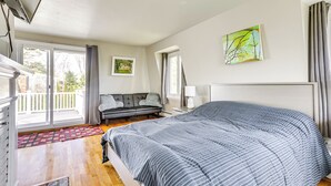 Une chambre avec un grand lit, un canapé, une fenêtre et un tableau au mur.
