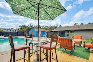 A poolside area with a table and chairs, an umbrella, and a pool. - Homosassa Getaway w/ Pool & Refreshed Lanai (Homosassa)