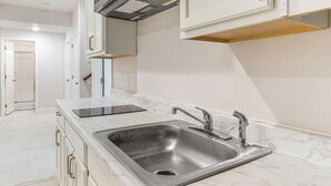 A kitchen with a stainless steel sink, white marble countertop, and white cabinetry. - 12 Mi to Hospitals: Modern Apartment in Aurora! (Aurora)