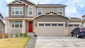 A two-story house with a red door, a garage, and a driveway. - 12 Mi to Hospitals: Modern Apartment in Aurora! (Aurora)
