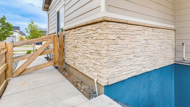 A corner of a building with a stone facade and a wooden gate. - 12 Mi to Hospitals: Modern Apartment in Aurora! (Aurora)