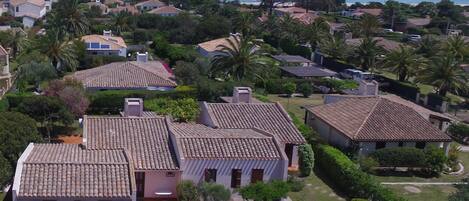 A residential area with houses, a garden, and a view of the sea.