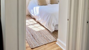 Un dormitorio con cama, alfombra y una lámpara de techo.