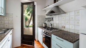 A kitchen with a stove, oven, and sink. - Villa '12' with Private Terrace, Wi-Fi and Air Conditioning (Costa Rei)