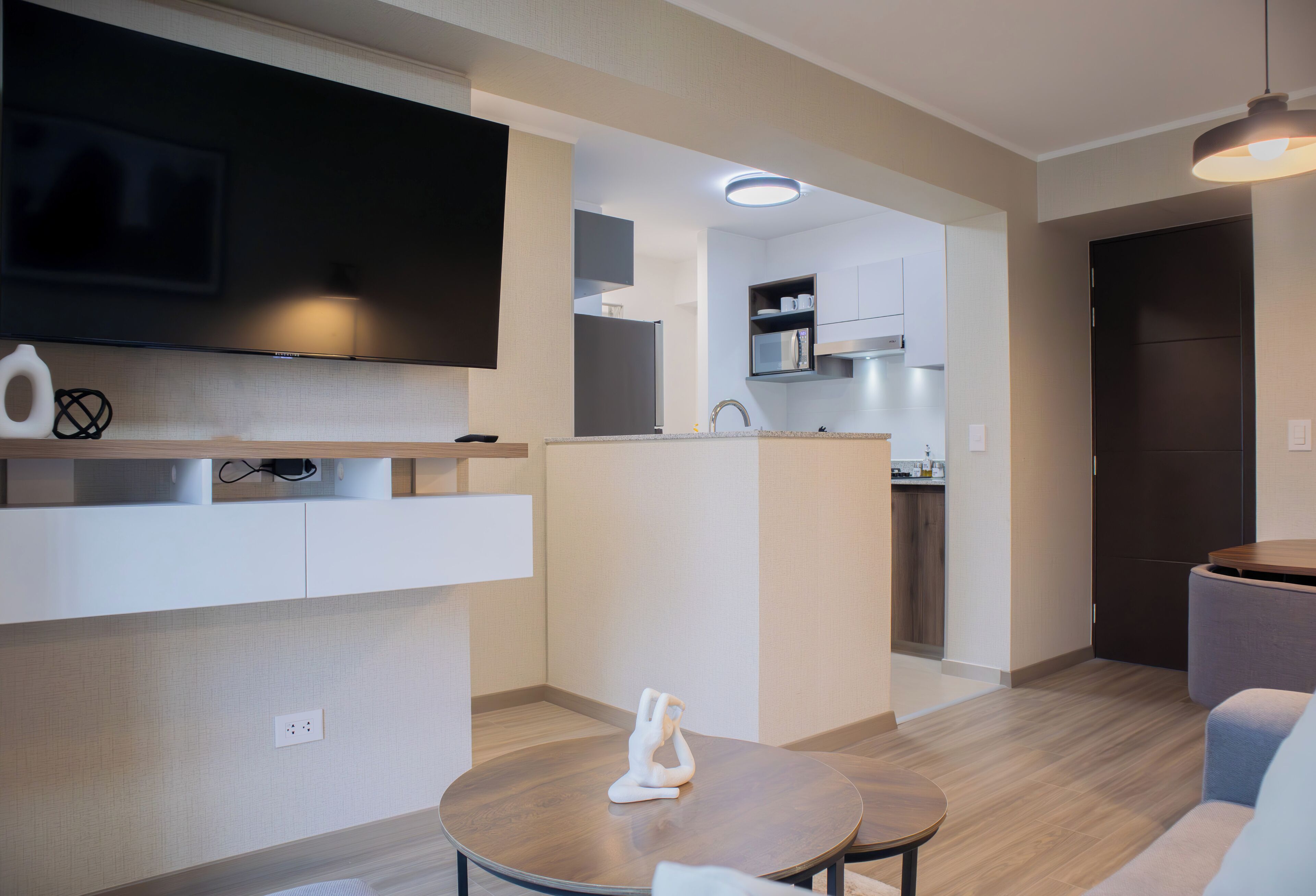 Un espacio moderno de estar con área de cocina, una mesa de comedor y un sofá.