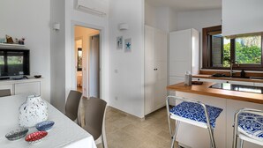 Una cocina moderna con encimera de madera, pileta integrada y ventana con vista a follaje.