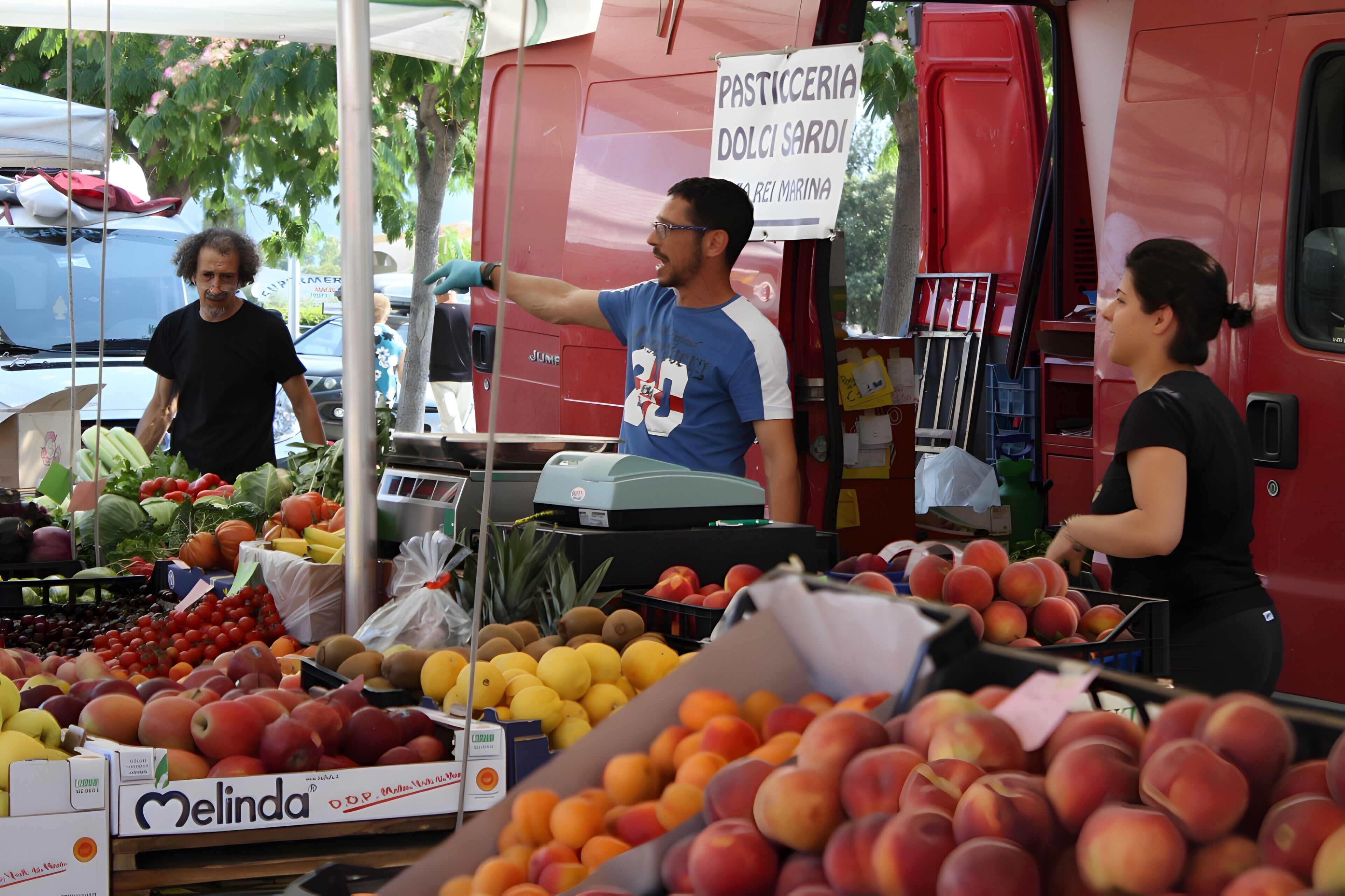 Un étal de fruits où l’on trouve une variété de fruits, ainsi qu’une enseigne indiquant « Pasticceria Dolce Sardi ».